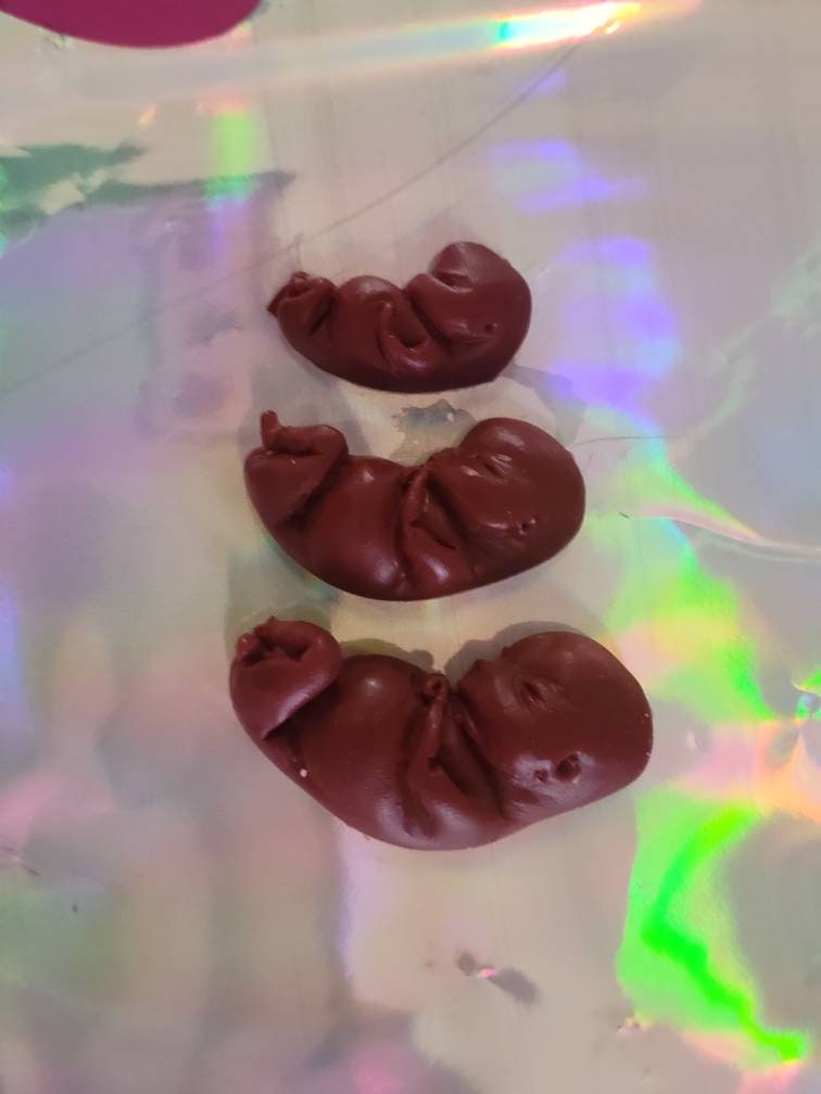 Dark red silicone fetus. You choose gestational sizing