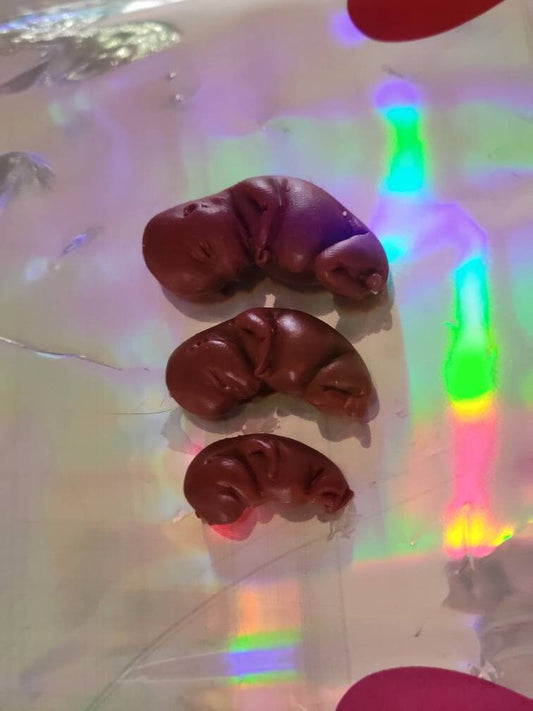 Dark red silicone fetus. You choose gestational sizing