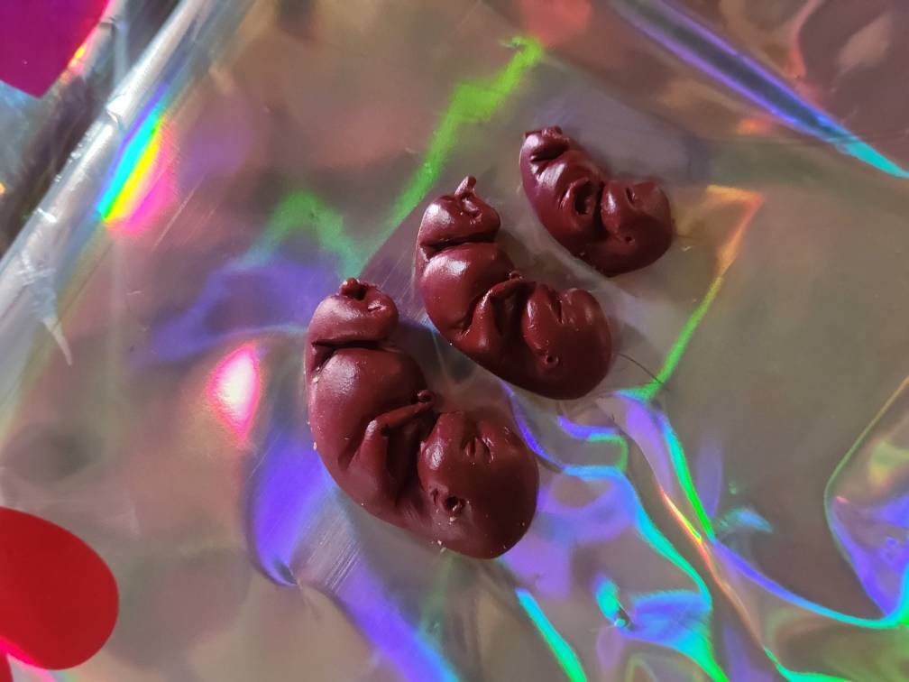 Dark red silicone fetus. You choose gestational sizing