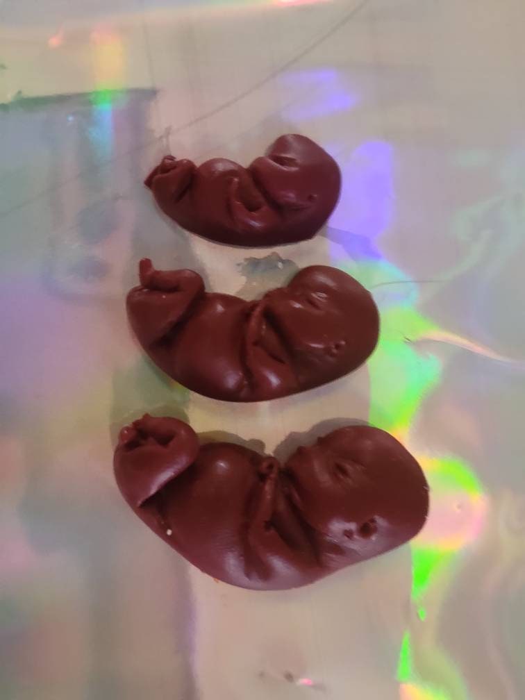 Dark red silicone fetus. You choose gestational sizing